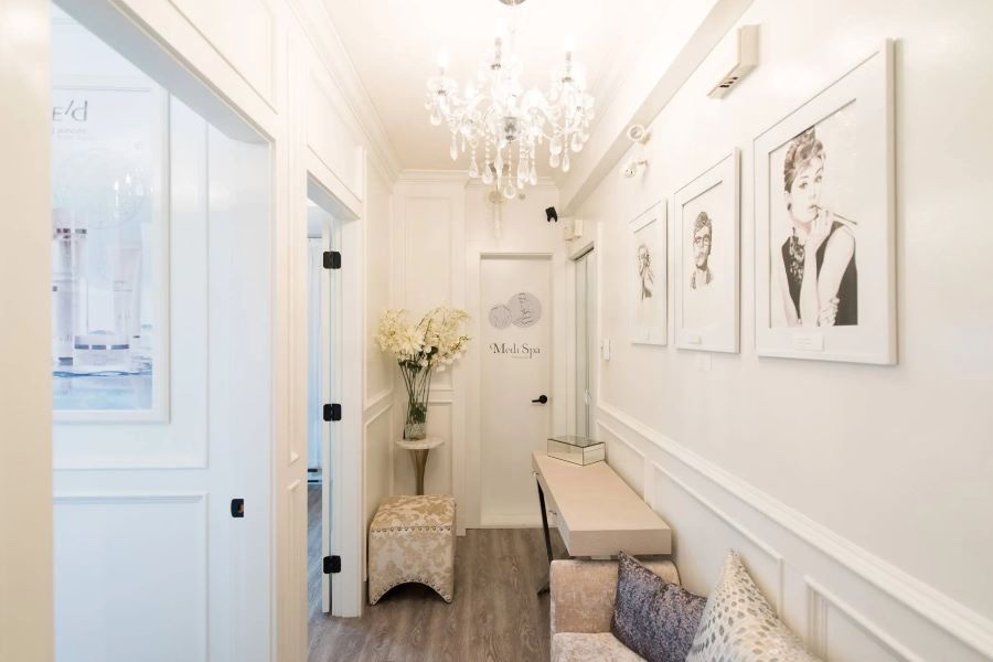 The white panelled hallway at Vancouver Medi Spa with its crystal chandelier